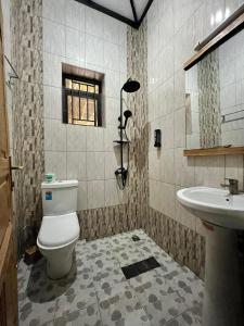 a bathroom with a toilet and a sink at URUGANO VIRUNGA PALACE in Nyarugina
