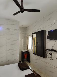 a bedroom with a ceiling fan and a bed at Eshwaraa Cottage in Palni