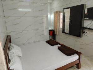 a bedroom with a white bed and a mirror at Eshwaraa Cottage in Palni