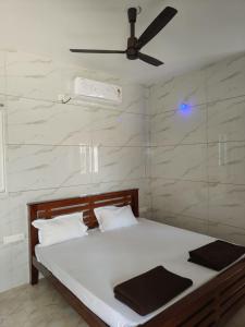 a bedroom with a bed with a ceiling fan at Eshwaraa Cottage in Palni