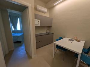 a small kitchen with a white table and blue chairs at Fp Monza Railways in Monza