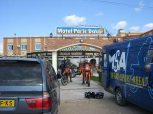 a couple of people on motorcycles parked next to a bus at Motel Paris Dakar in Selouane