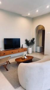 a living room with a couch and a tv on a wall at Pinggan Foggy in Baturaja