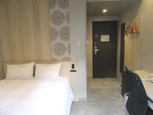 a bedroom with a white bed and a black door at Smile Hotel Hachinohe in Hachinohe +52 photos