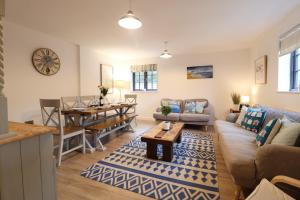 a living room with a couch and a table at Corner Cottage, Thorpeness in Thorpeness +23 photos