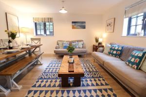 a living room with a couch and a table at Corner Cottage, Thorpeness in Thorpeness