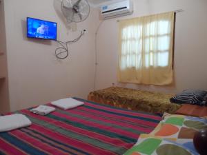 1 dormitorio con 2 camas y TV en la pared en Alquiler Temporario Salta en Salta
