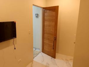 a room with a wooden door and a television at K.Y.M Pension House in Moalboal +25 photos
