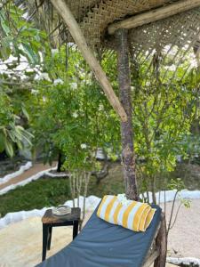 a bed with a blue and yellow pillow on it at Embe Lodge in Kizimkazi