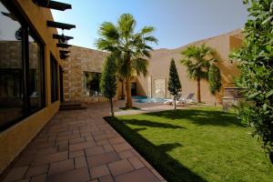 a courtyard with palm trees and a building at Marbella Resort in Al ‘Ammārīyah