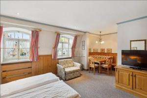 a bedroom with a television and a dining room table at Gästehaus Blaue Ecke in Adenau +31 photos