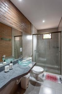 a bathroom with a sink and a toilet and a shower at Chalé Belvedere Veadeiros in Alto Paraíso de Goiás