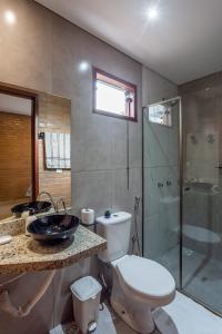 a bathroom with a toilet and a sink and a shower at Chalé Belvedere Veadeiros in Alto Paraíso de Goiás