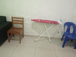 a table with a surfboard on it next to a chair at JAA Homes 1-8 Pax Family Stay Jalan UMS KK in Kota Kinabalu