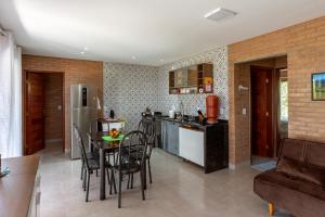 a kitchen with a table and chairs in a kitchen at Chalé Belvedere Veadeiros in Alto Paraíso de Goiás