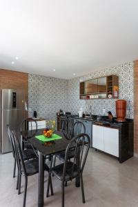 a kitchen with a table and chairs and a refrigerator at Chalé Belvedere Veadeiros in Alto Paraíso de Goiás