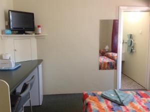 a hotel room with a desk and a bed and a television at Murray Bridge Motor Inn in Murray Bridge