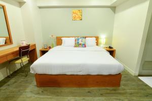 a bedroom with a bed and a desk with a mirror at BJ Boutique in Rayong