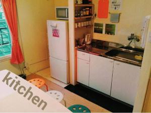 a kitchen with a white refrigerator and a sink at 高松guesthouseOLD in Takamatsu +20 photos