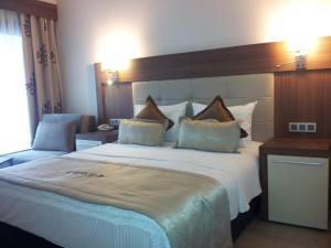a hotel room with a large bed with white sheets at Vesta Fuar Otel in Konak +17 photos