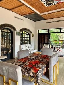 a dining room with a table and chairs and windows at URUGANO VIRUNGA PALACE in Nyarugina