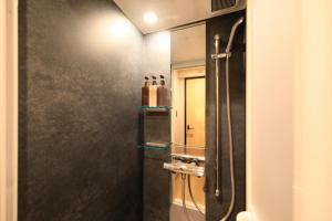 a bathroom with a shower with a black wall at ゆるり箱根withDOGS in Hakone