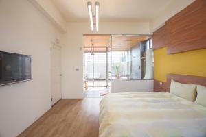 Un dormitorio con una cama grande y un televisor. en 采虹6號民宿臺東縣民宿479號, en Taitung 27 fotos más
