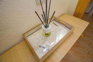 a wooden table with a vase with sticks in it at Mona Baltico-Traveller Awards 2026 in Torrevieja +26 photos