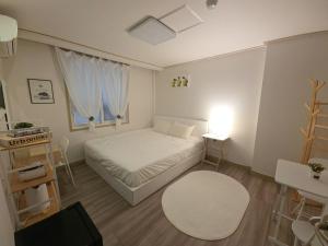 a small bedroom with a bed and a table at G Hotel near Busan Station in Busan