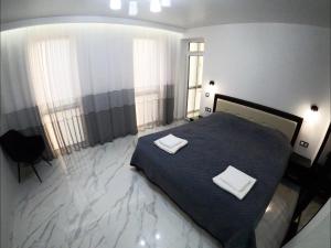 a bedroom with a bed with two white towels on it at Апартаменты Сонячний квартал in Golubinoye +4 photos