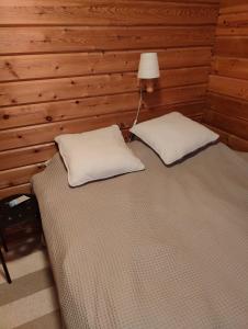 ein Schlafzimmer mit einem Bett und zwei weißen Kissen in der Unterkunft Suomunkutsu 2 in Suomutunturi