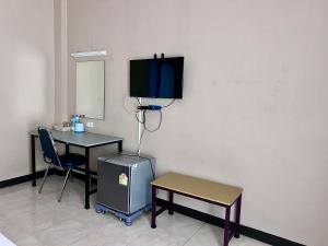 a room with a table and a tv on the wall at โรงแรมสิริพรชัย in Takua Pa