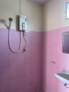 a pink bathroom with a shower and a sink at โรงแรมสิริพรชัย in Takua Pa