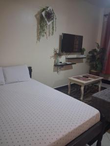 a bedroom with a bed and a tv and a table at PAZURI - Homes in Voi