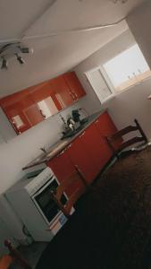 a kitchen with red cabinets and a sink at Rez chaussée transformé en t4 au 114 Avenue de juvisy cottages in Juvisy-sur-Orge