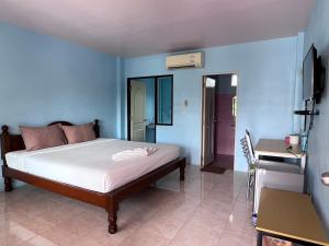 a bedroom with a bed and a blue wall at โรงแรมสิริพรชัย in Takua Pa