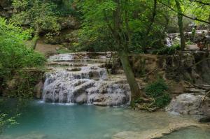 a waterfall in the middle of a pool of water at Guest House Ongal in Krushuna