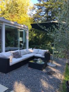 eine Couch und ein Sonnenschirm im Garten in der Unterkunft BaumbergIdyll in Billerbeck