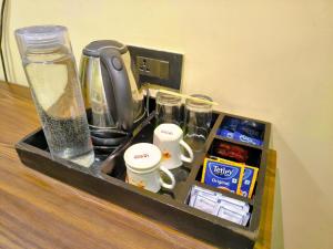 a tray with cups and other items on a counter at Arcadian Hotel in Gangtok