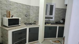 a kitchen with a microwave on a counter at Studio Bayen in Douz