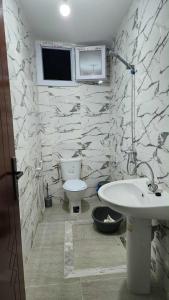 a bathroom with a white sink and a toilet at Studio Bayen in Douz