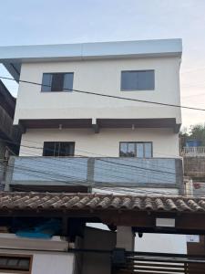 a tall white building with a tile roof at Serra Premium Residence in Petrópolis