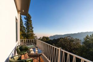a balcony with chairs and a table and a view at Moustache Select Nainital- Onsite Parking in Nainital