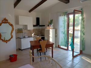 a kitchen with a wooden table and a kitchen with a refrigerator at Qui vive un sogno in Roccastrada