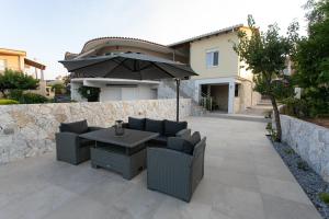a patio with a table and chairs and an umbrella at Akrolithia Guest House in Valanidorachi