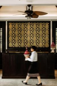 a woman walking in front of a wall at Souphattra Hotel Luang Prabang in Luang Prabang +91 photos