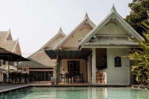 a house with a swimming pool in front of it at Souphattra Hotel Luang Prabang in Luang Prabang