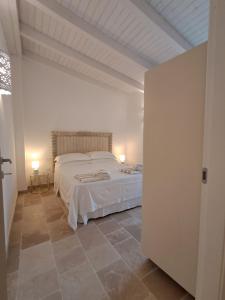 a bedroom with a large white bed in a room at Masseria Palane in Patù +153 photos