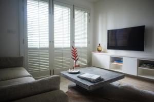 a living room with a couch and a tv at Luxe320 in Colombo