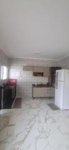 a kitchen with a white refrigerator in a room at Rancho Duarte in Itanhaém